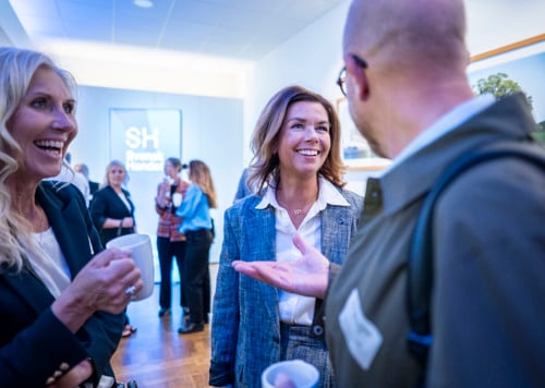 En grupp människor som står och pratar med varandra.