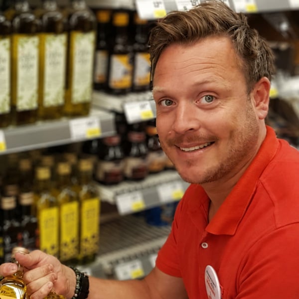 En man som håller en vinflaska i en butik.