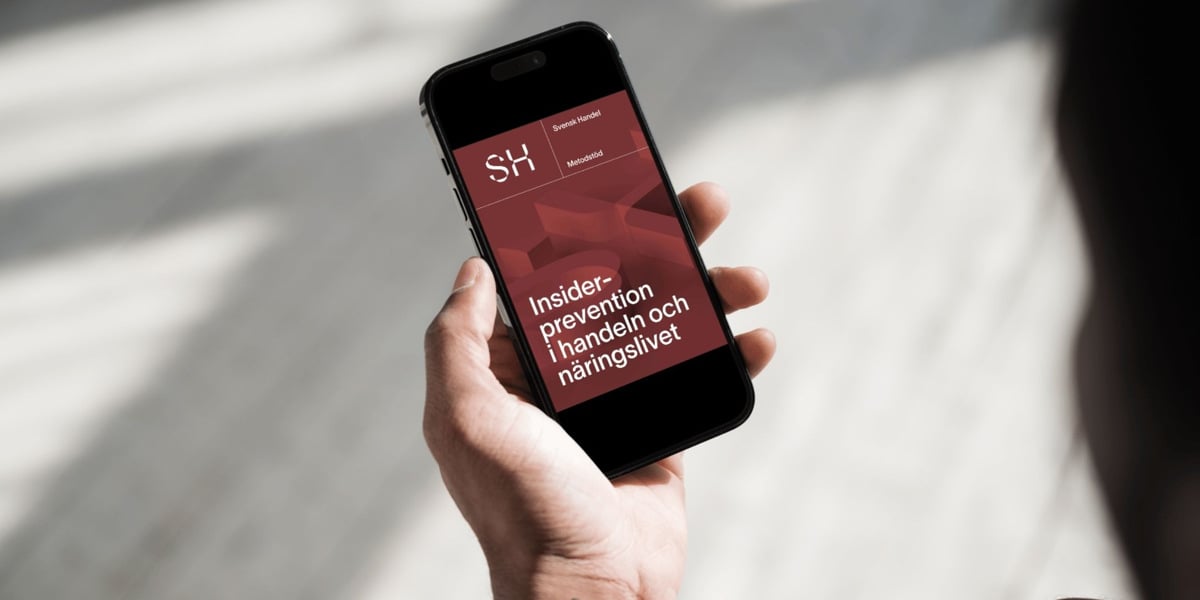 En person som h&aring;ller en mobiltelefon i handen.