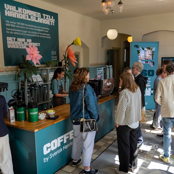 En grupp människor som står runt ett kafé.