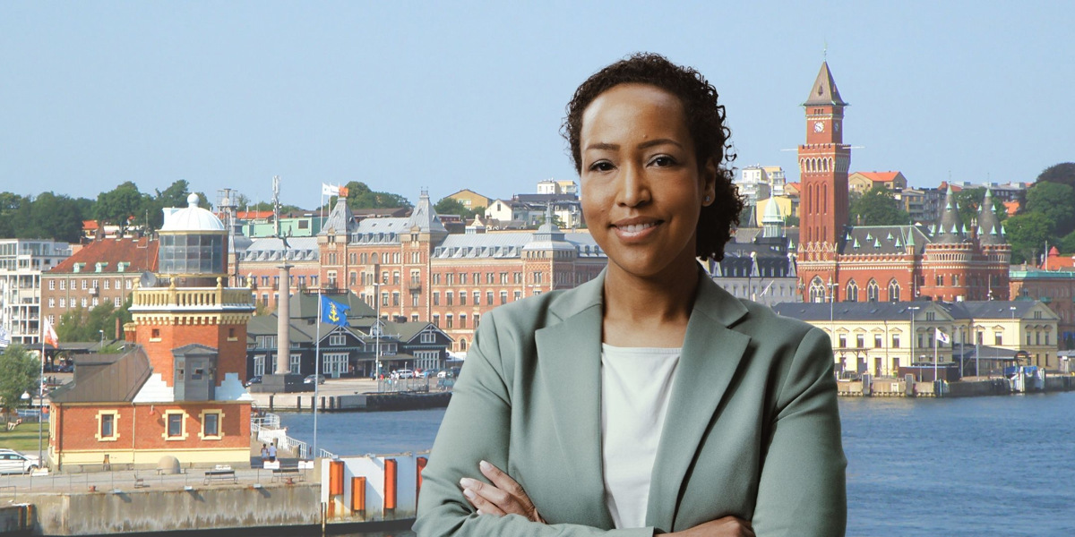 En kvinna som står framför en vattenyta.