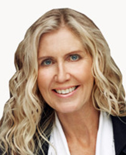 En kvinna med blont hår och svart jacka.