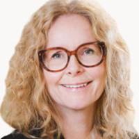 En kvinna med glasögon och svart skjorta.
