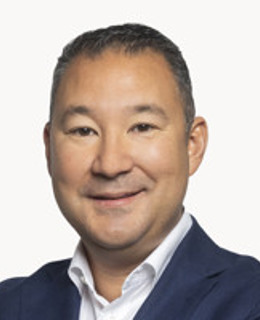 En man klädd i blå jacka och vit skjorta.