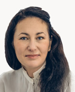 En kvinna med långt hår som bär en vit skjorta.