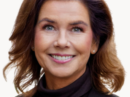 En kvinna i svart jacka och tröja med polokrage.