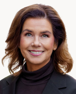 En kvinna i svart jacka och tröja med polokrage.