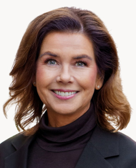 En kvinna i svart jacka och tröja med polokrage.