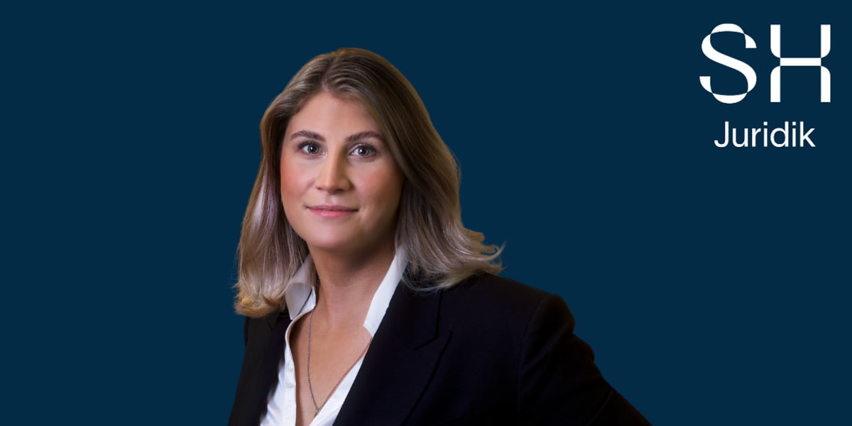 En kvinna i aff&auml;rskostym poserar f&ouml;r en bild.