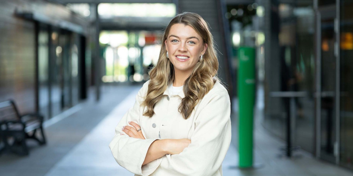 En kvinna st&aring;r framf&ouml;r en t&aring;gstation.