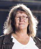 En kvinna med glasögon och en vit skjorta.