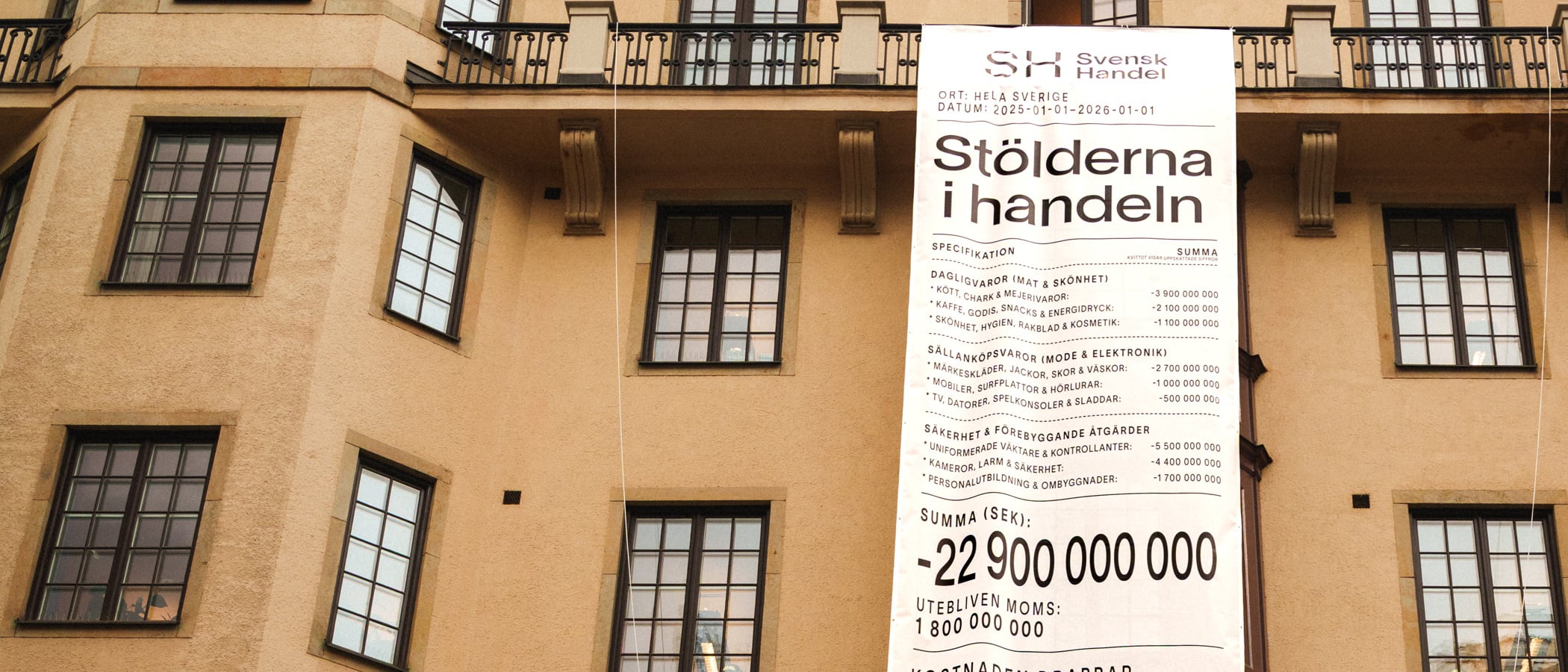 En hög byggnad med en skylt som hänger på sidan.