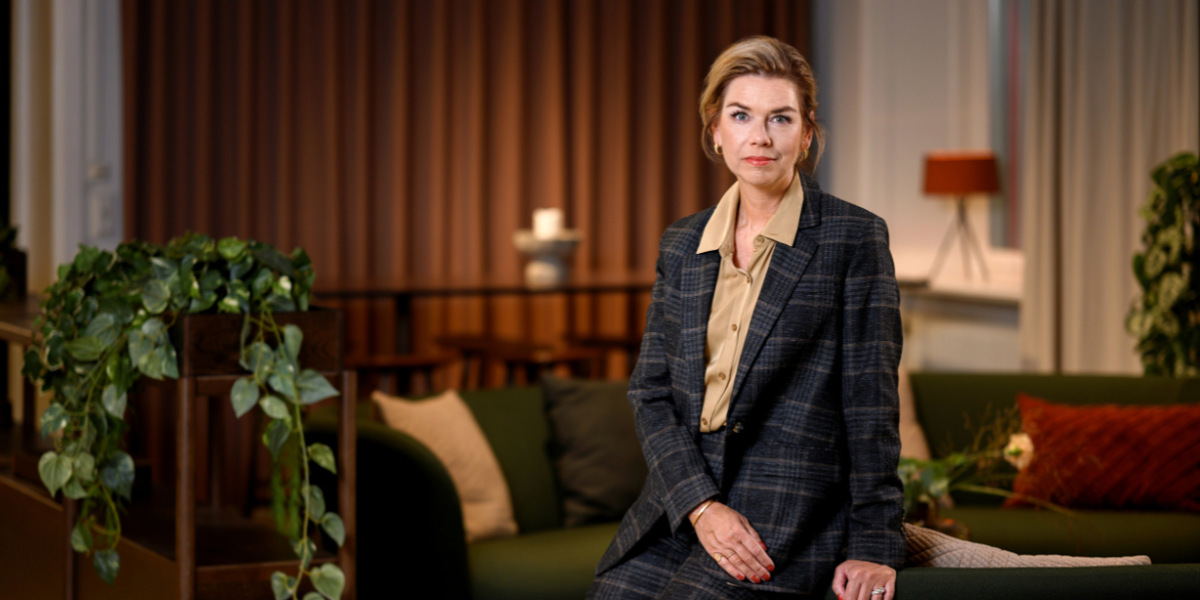En kvinna som sitter på en soffa i ett vardagsrum.