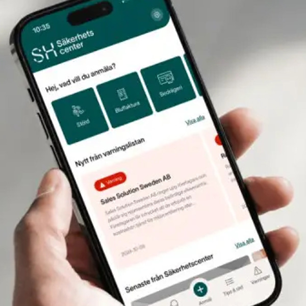 En person som håller en mobiltelefon i handen med appen Säkerhetscenter.
