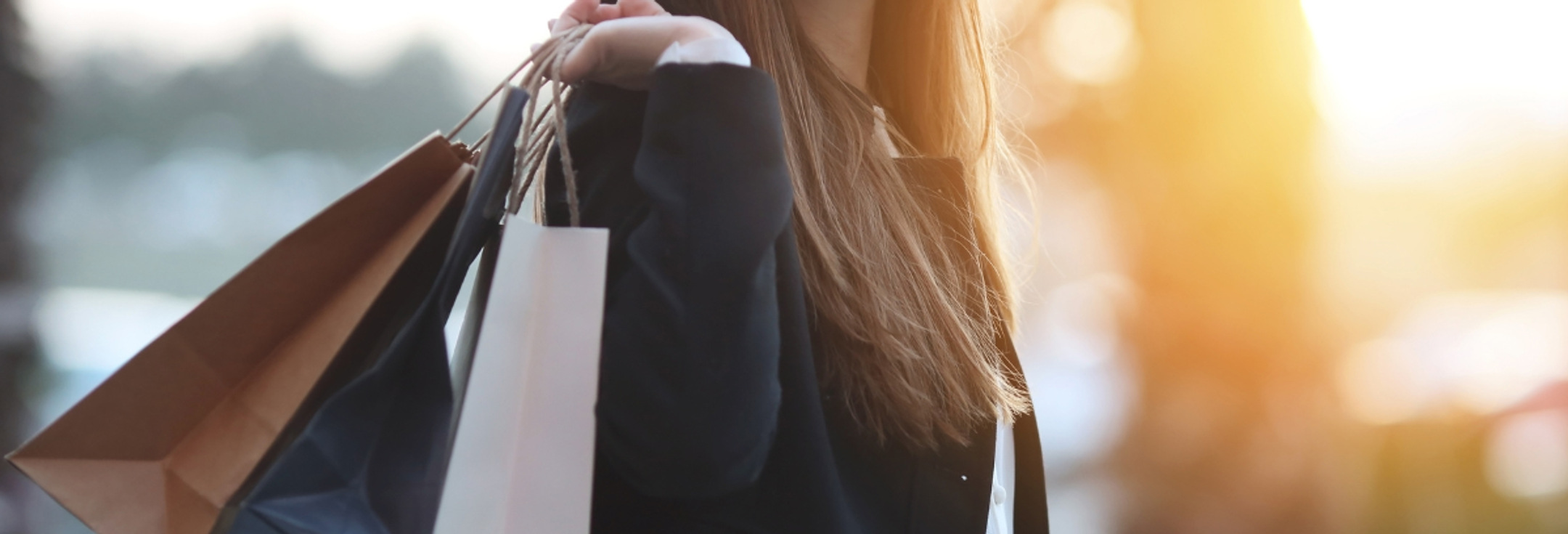 En kvinna med shoppingkassar i händerna.