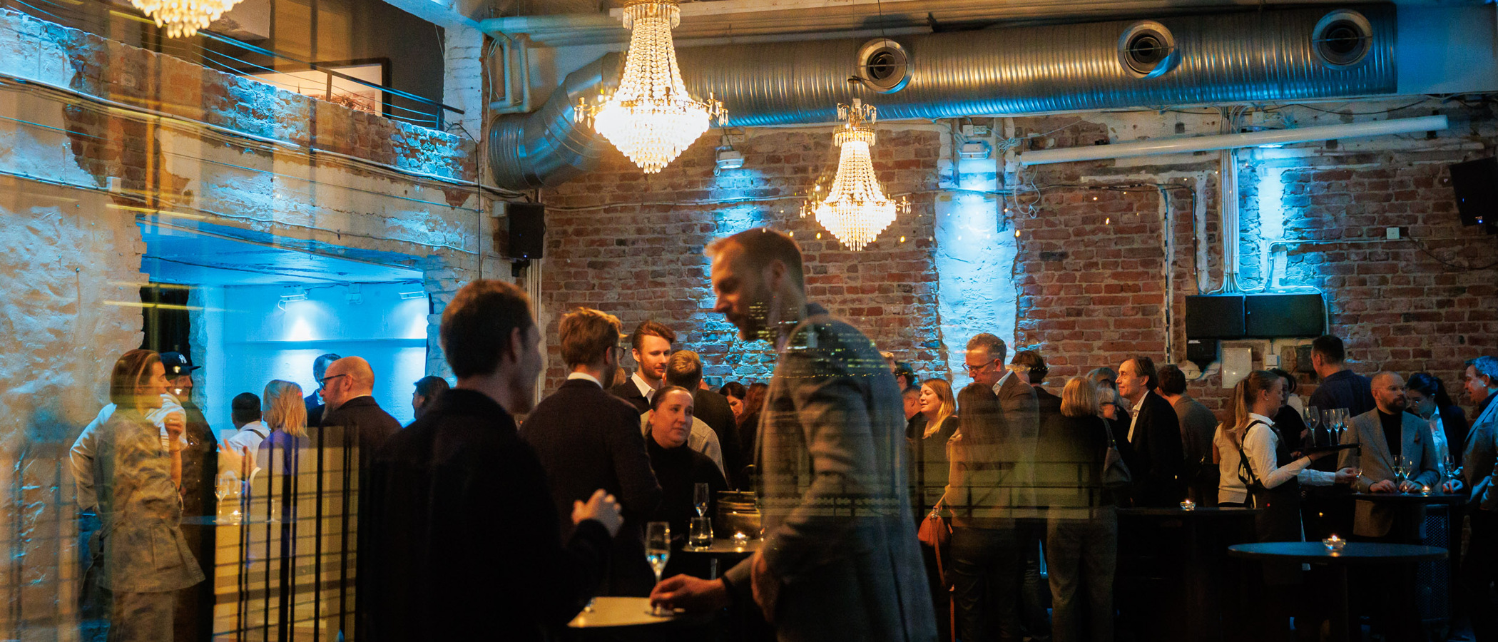 En grupp människor som står och väntar i ett rum.