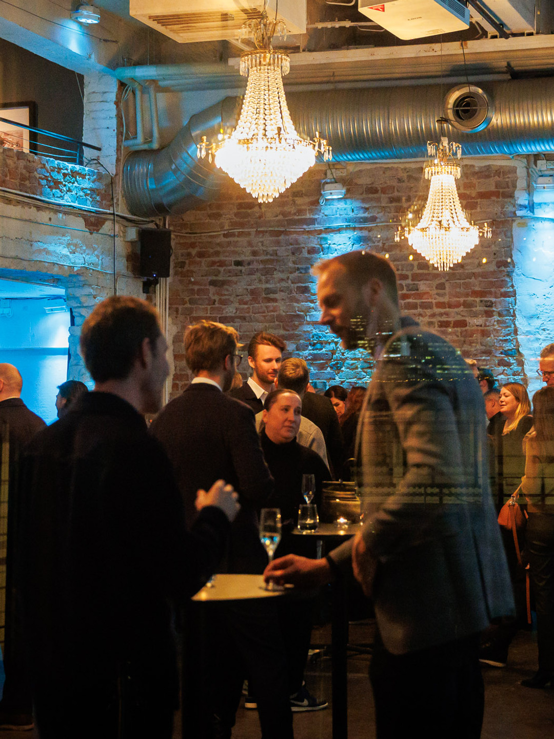 En grupp människor som står och väntar i ett rum.