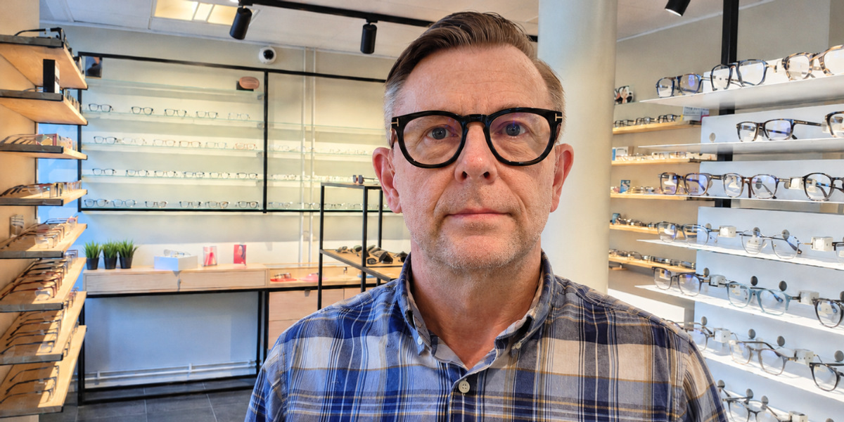En man som står framför ett glasutställningsfönster.