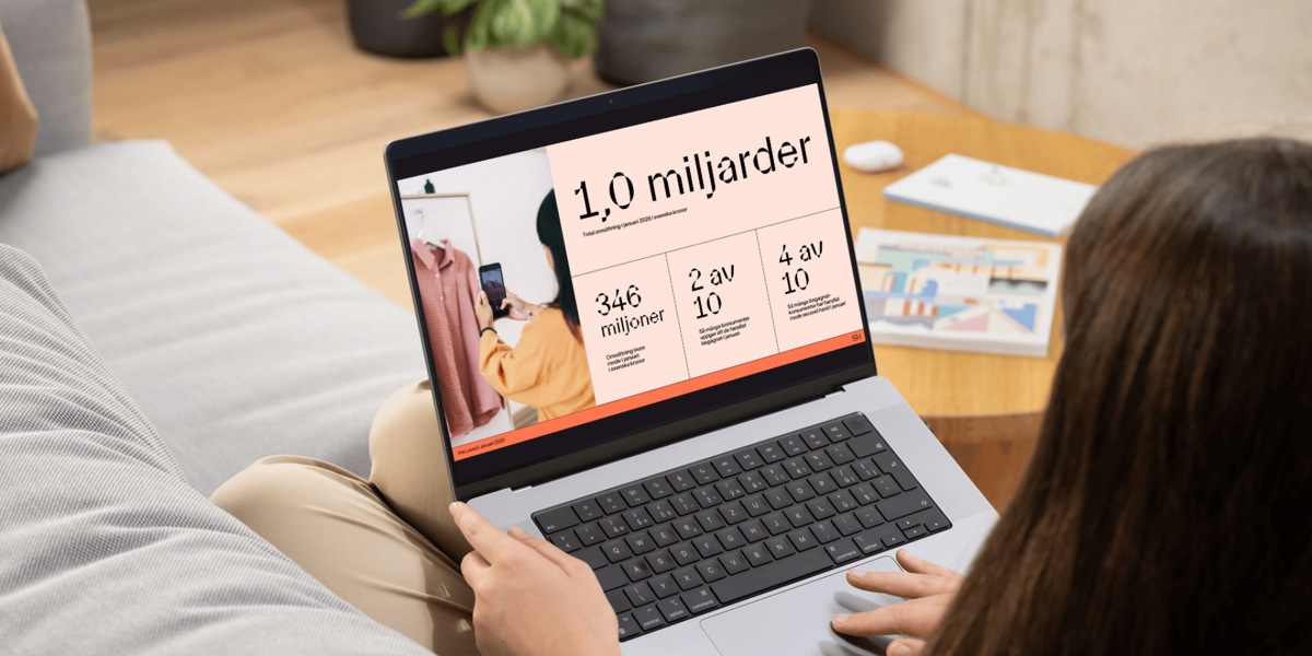 En kvinna sitter i en soffa och använder en bärbar dator.