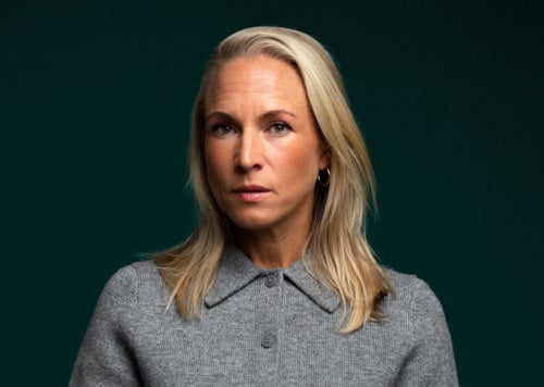 En kvinna som står med händerna i fickorna.