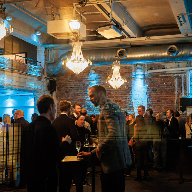 En grupp människor som står och väntar i ett rum.