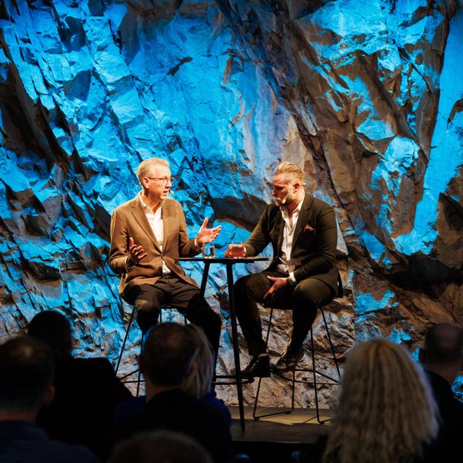 Några män som sitter bredvid varandra på en scen.