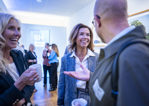 En grupp människor som står och pratar med varandra.