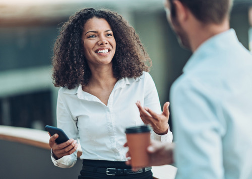 En kvinna pratar med en man i vit skjorta.