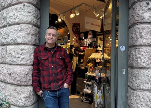 En man som står i dörröppningen till en butik.