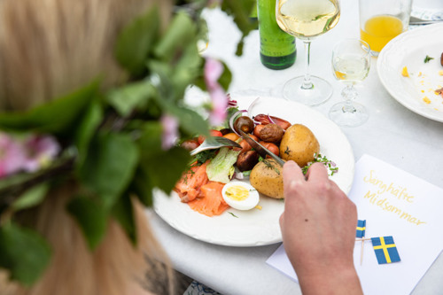 En person som skär upp en tallrik med mat på ett bord.