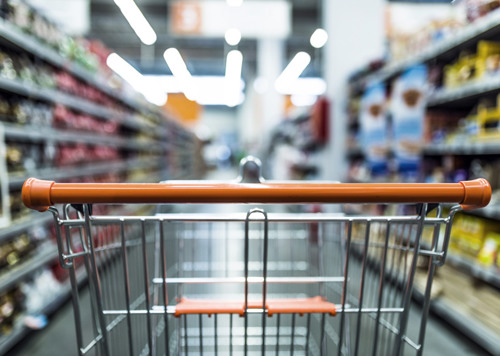 En kundvagn i en gång i en livsmedelsbutik.