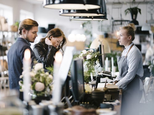 Några personer som står framför en disk i en butik.