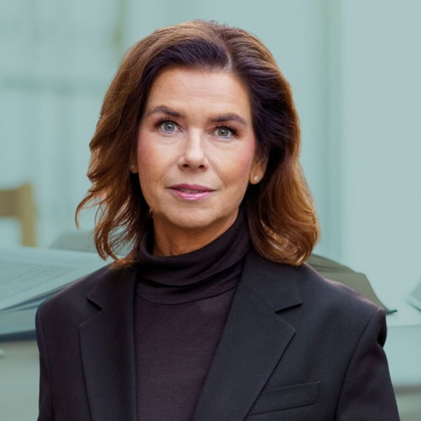 En kvinna står framför ett skrivbord.