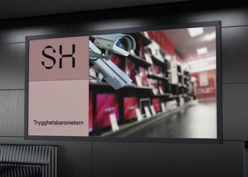 En stor skärm i en byggnad med en bänk framför sig.