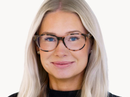 En kvinna med långt blont hår som bär glasögon.