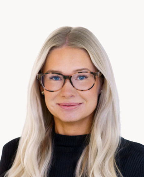 En kvinna med långt blont hår som bär glasögon.