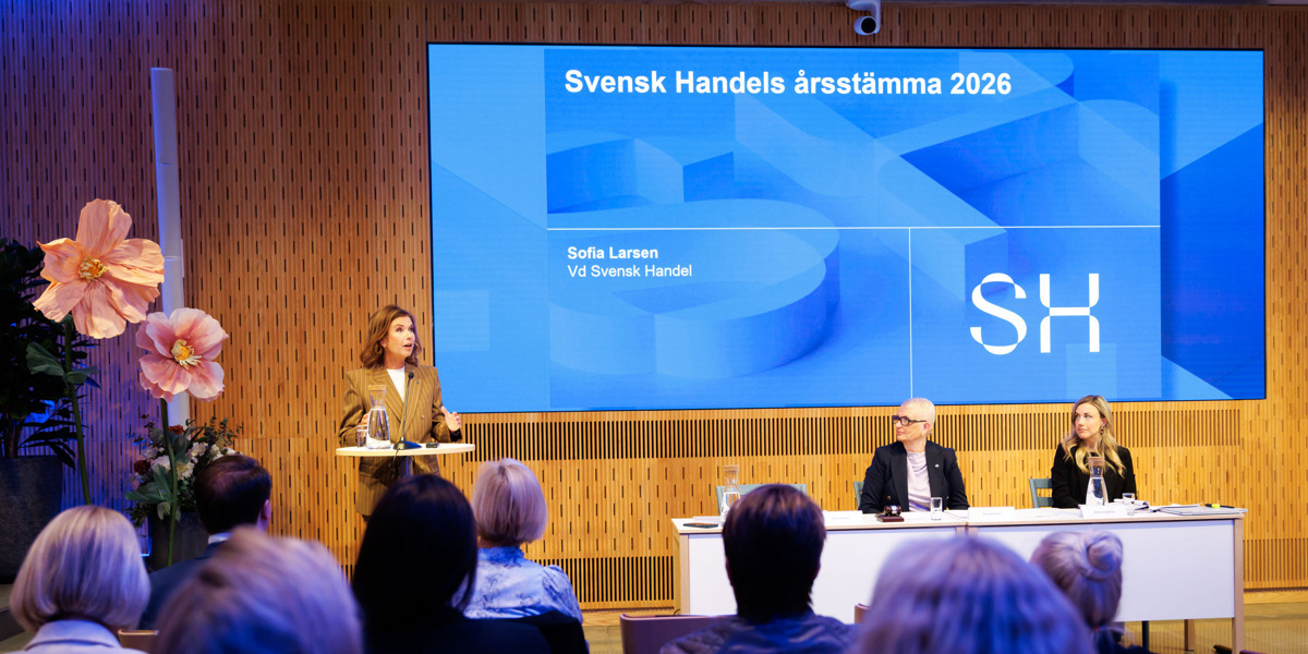 En grupp människor som sitter vid ett bord framför en folkmassa.