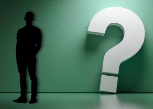 En man som står framför ett vitt frågetecken.