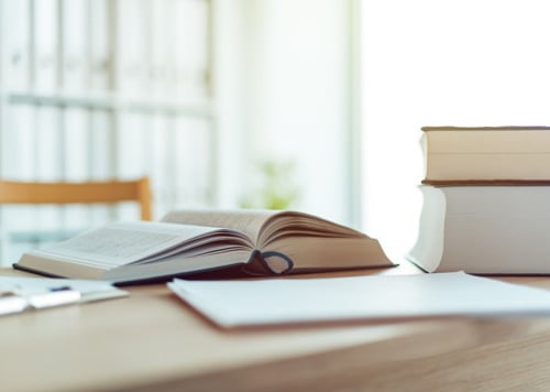 En öppen bok som ligger på ett träbord.