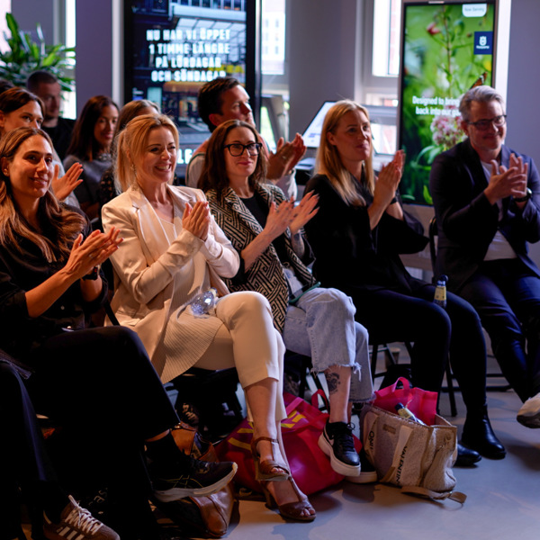 En grupp människor som sitter i ett rum och klappar.