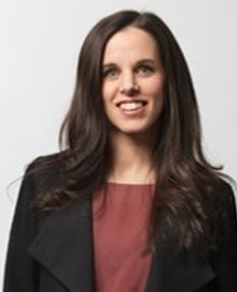 En kvinna i svart jacka och röd topp.