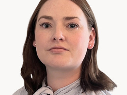 En kvinna i grå skjorta och slips.