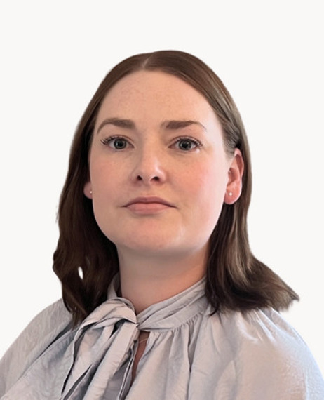 En kvinna i grå skjorta och slips.