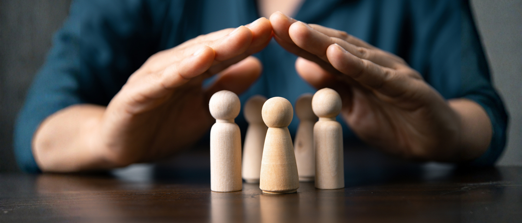 En grupp små träfigurer som sitter på ett bord.