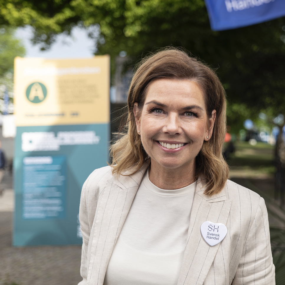 En kvinna står framför en byggnad.