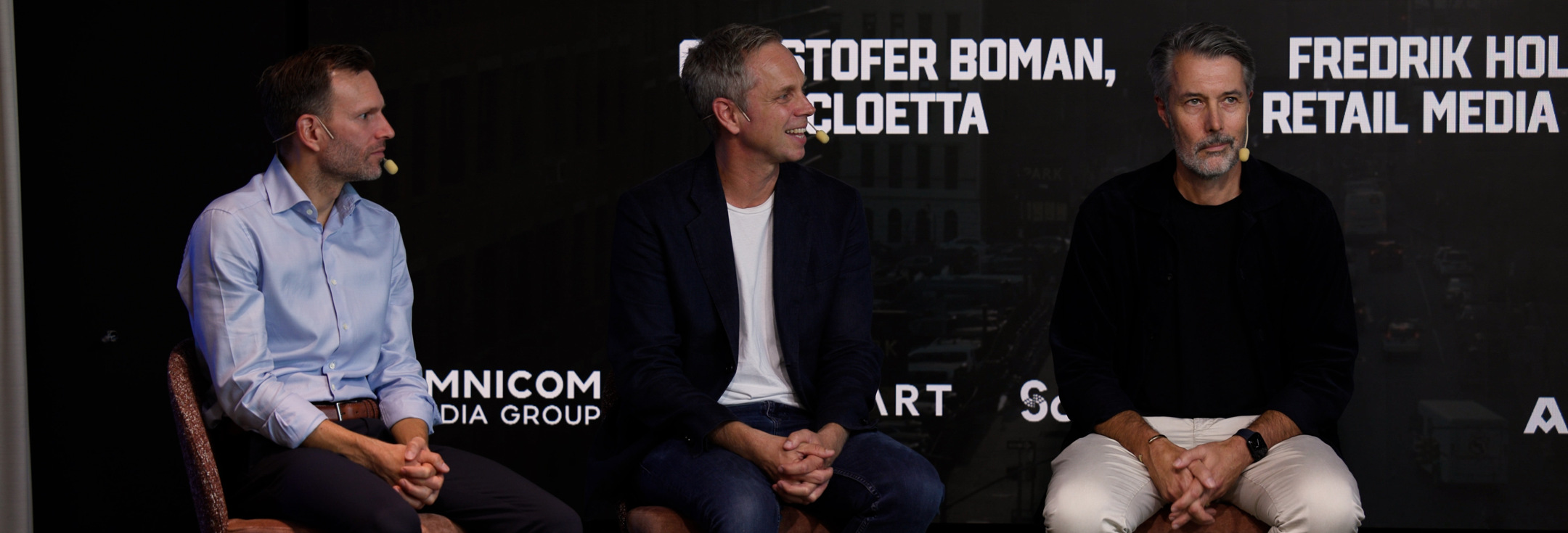 En grupp män som sitter bredvid varandra på en scen.