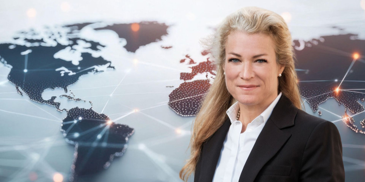 En kvinna står framför en världskarta.