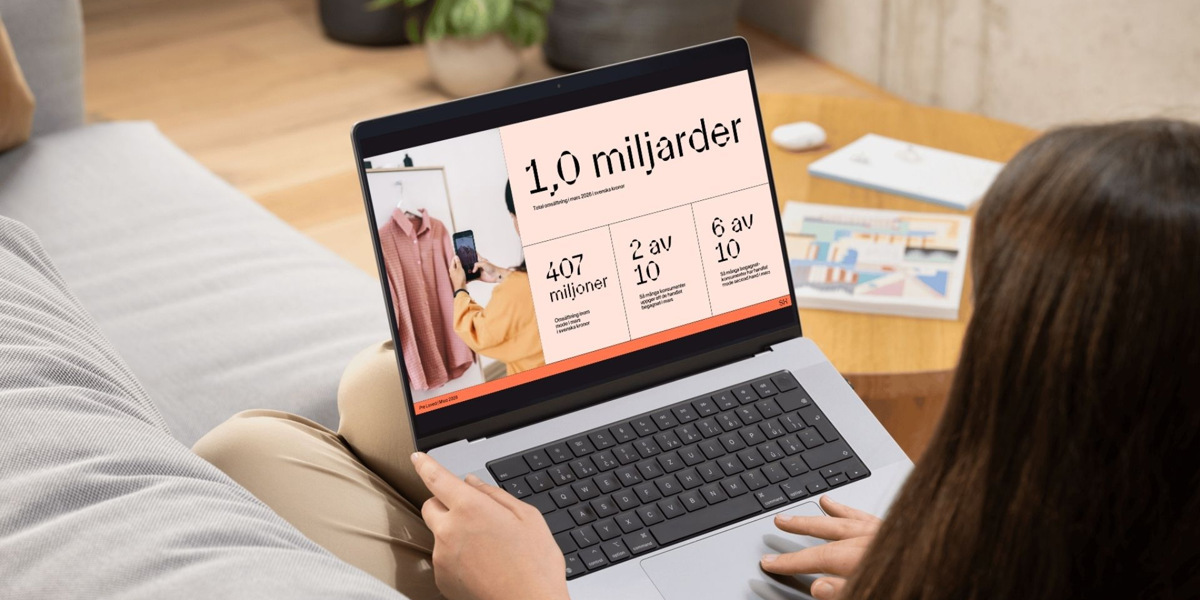 En kvinna sitter i en soffa och använder en bärbar dator.