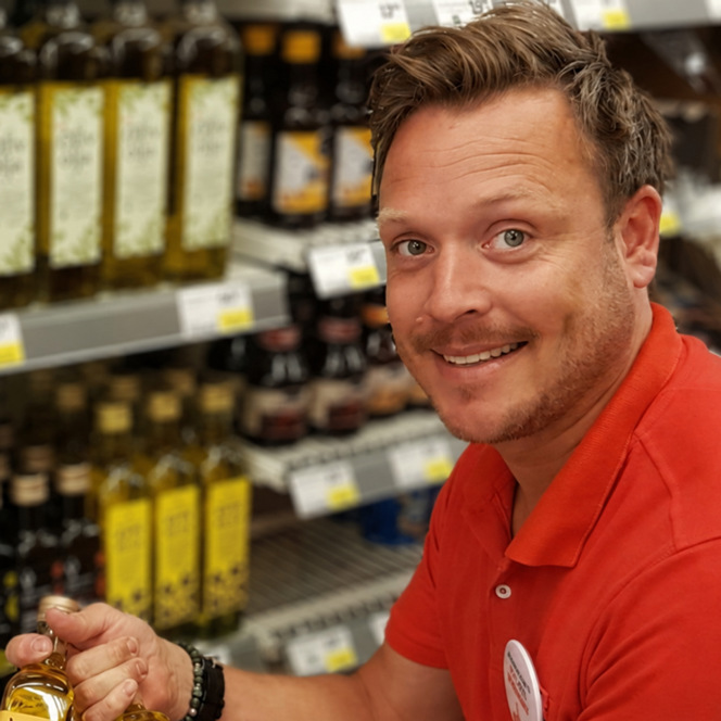 En man som håller en vinflaska i en butik.