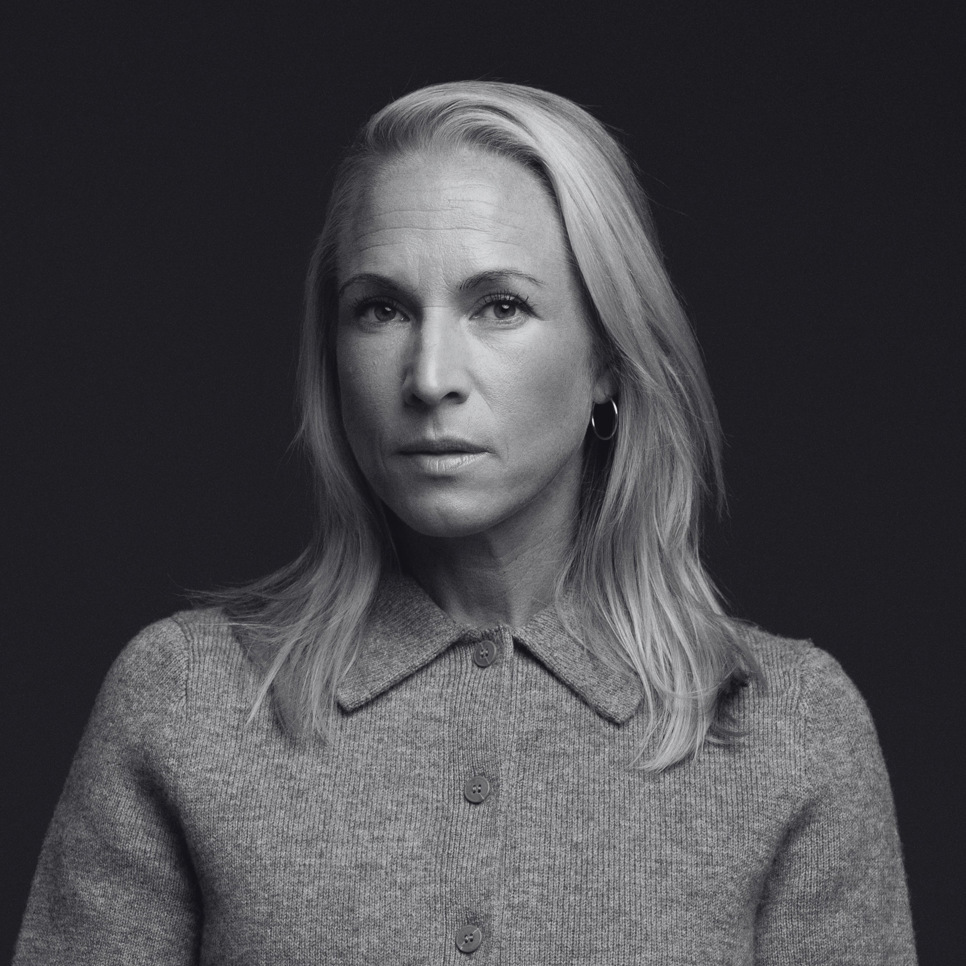 En kvinna som står framför en svart bakgrund.